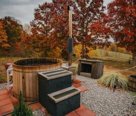 Private cedar hot tub surrounded by fall foliage at Nature Mystique Retreat