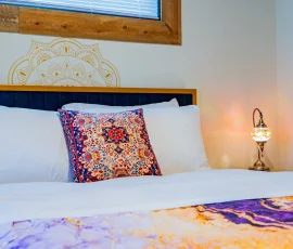 Close-up of decorative bed pillow and lamp in Tangier Aladdin-inspired cabin at Nature Mystique Retreat
