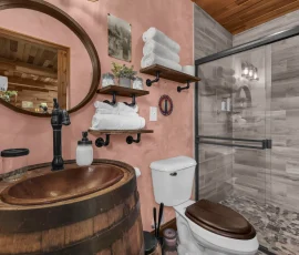 Bathroom with whiskey barrel sink in Daisy Hobbit-inspired cabin at Nature Mystique Retreat