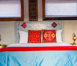 Bed with decorative pillows and lamps in Marrakesh Aladdin-inspired cabin at Nature Mystique Retreat