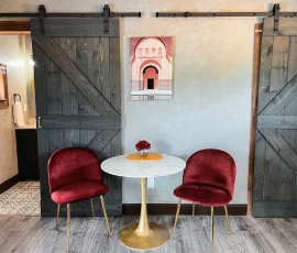 Table with two chairs near barn door in Marrakesh Aladdin-inspired cabin at Nature Mystique Retreat