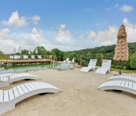 Lounge chairs on the sandy beach beside the natural swimming hole at Nature Mystique Retreat