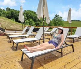 Woman relaxing on a lounge chair on the deck at Nature Mystique Retreat