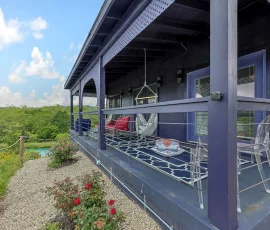 Balcony with chairs and hammocks overlooking lake at Tangier Aladdin-inspired cabin at Nature Mystique Retreat