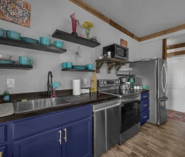 Full kitchen with sink, dishwasher, oven, microwave, and large refrigerator in Tangier Aladdin-inspired cabin at Nature Mystique Retreat